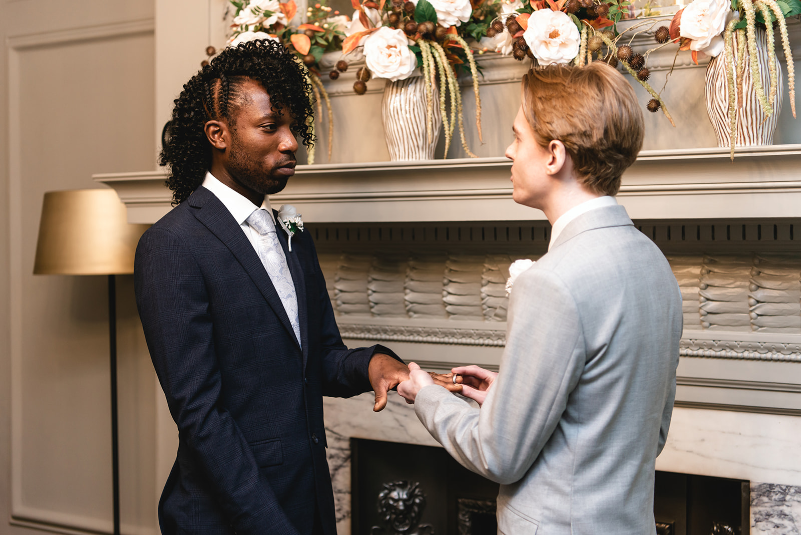 Benjamin and Ezekiel's ring exchange during the wedding ceremony in the Soho Room at Marylebone Town Hall