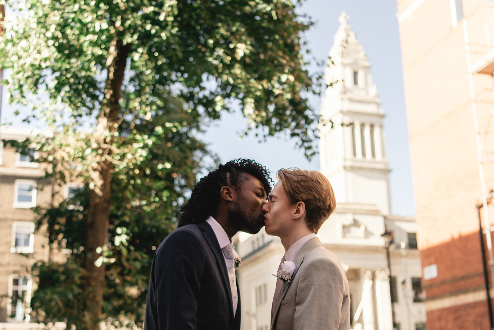Sweet portrait of Benjamin and Ezekiel kissing in the streets of London