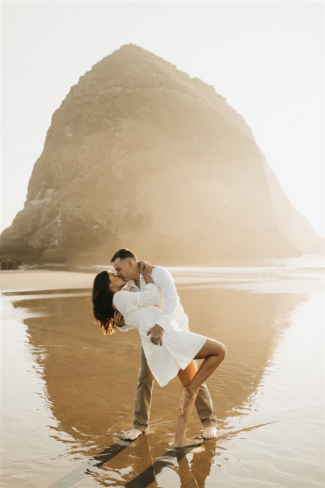 a couple kissing on the beach In front of haystack rock on cannon beach oregon 