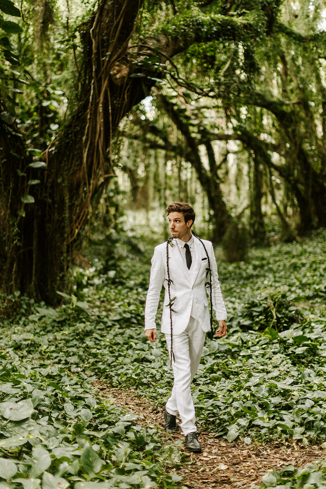 A couple who just got married celebrate their Maui elopement in a hawaii forest with lush greenery and jungle 
