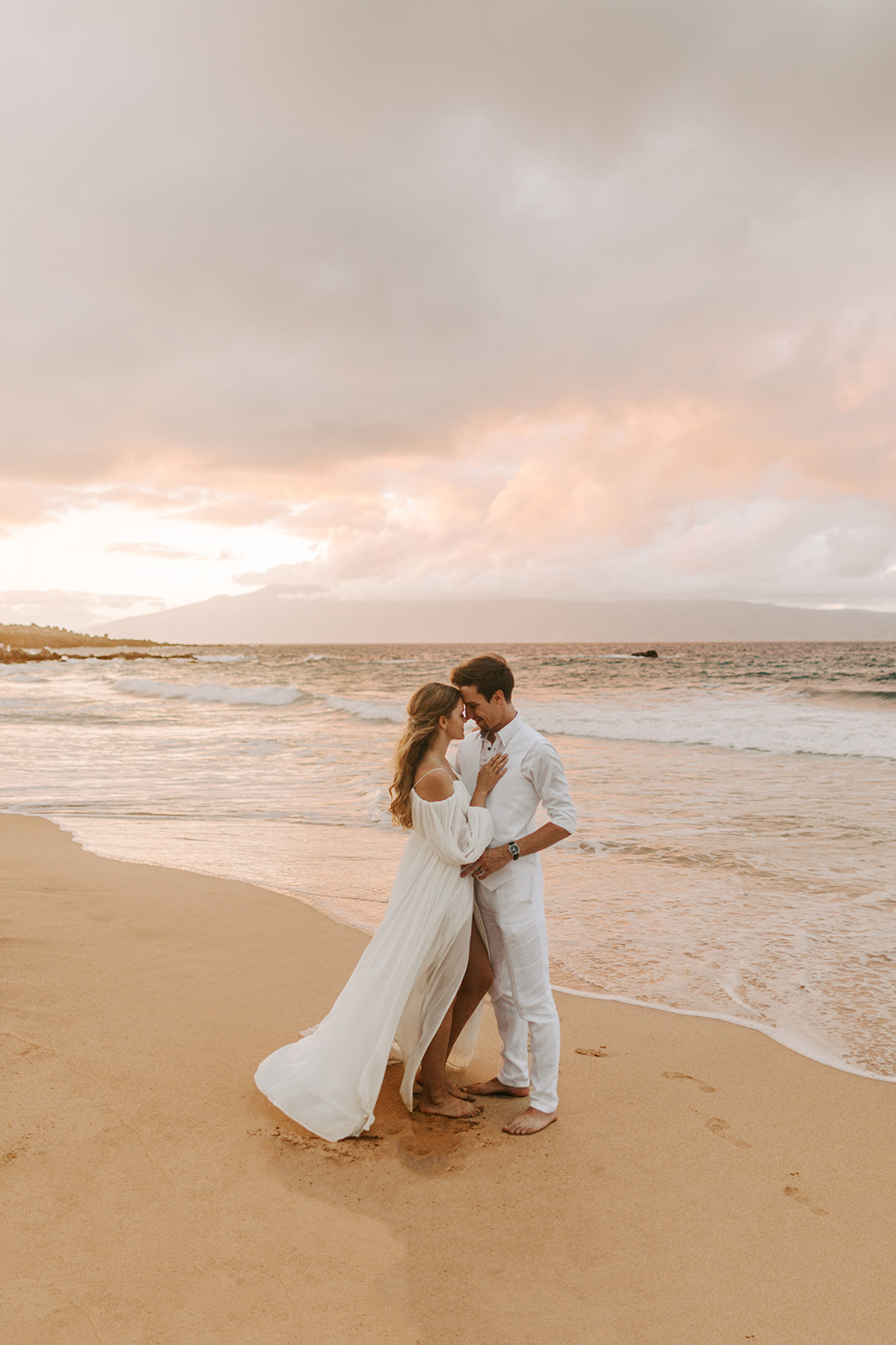 A couple who just got married in Maui watch the sunset together after their hawaii elopement