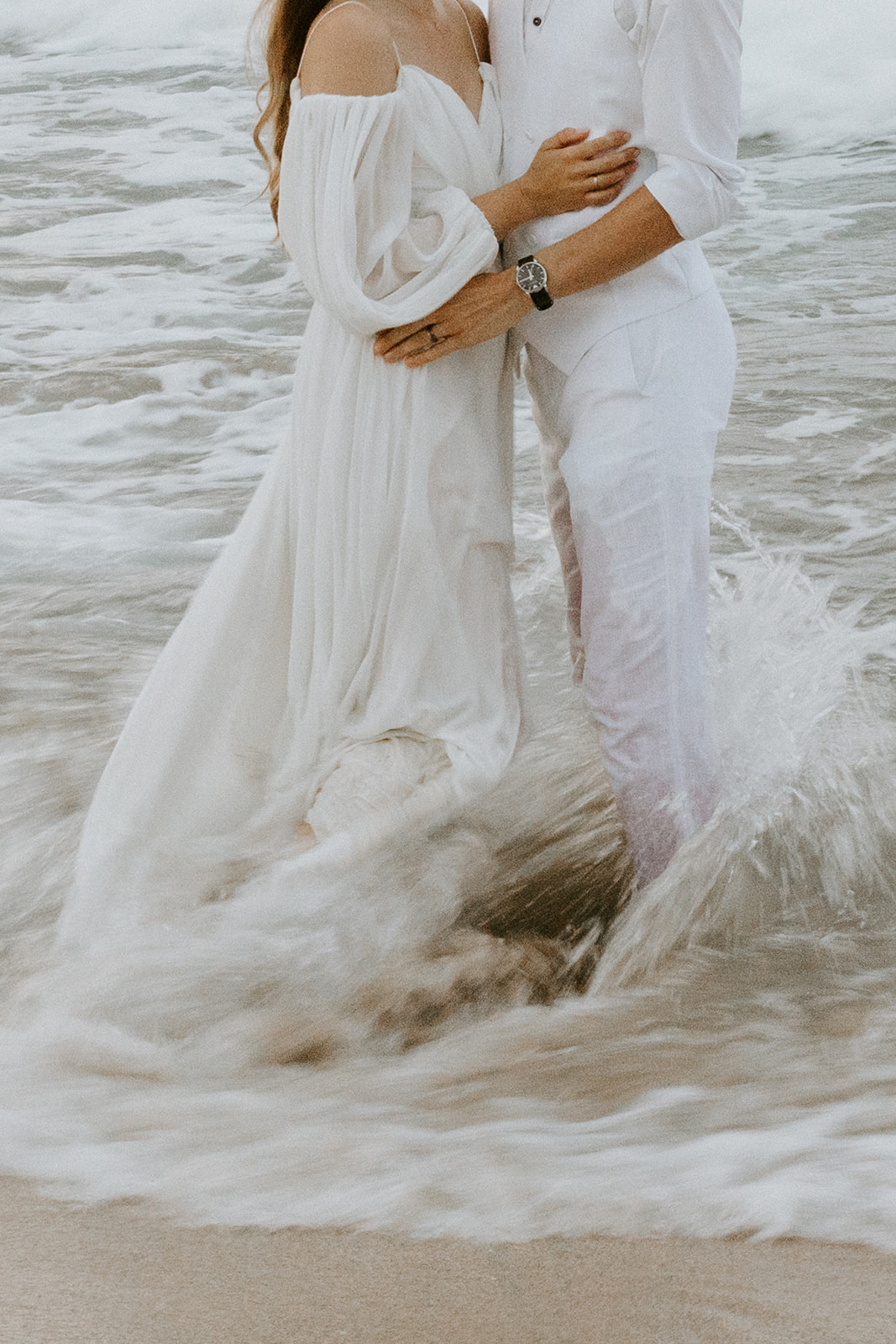 A couples runs into the ocean for their Hawaii trash the dress session 