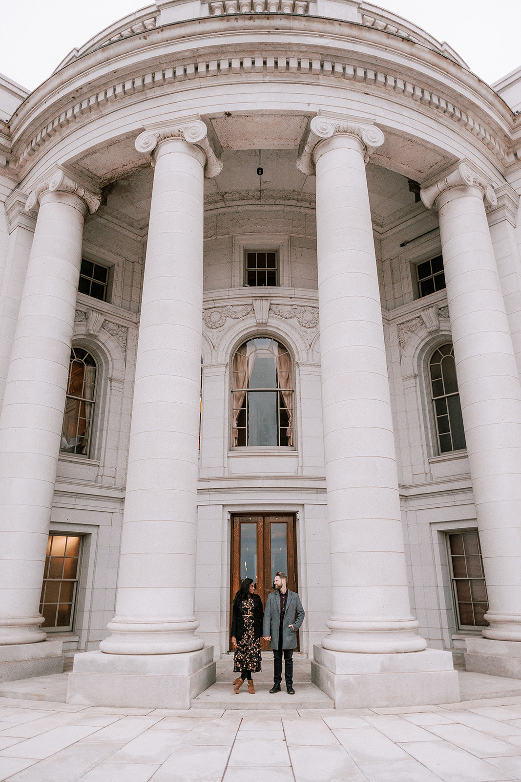 couple stands in front of the madison wisconsin capitol building during their late fall engagement session