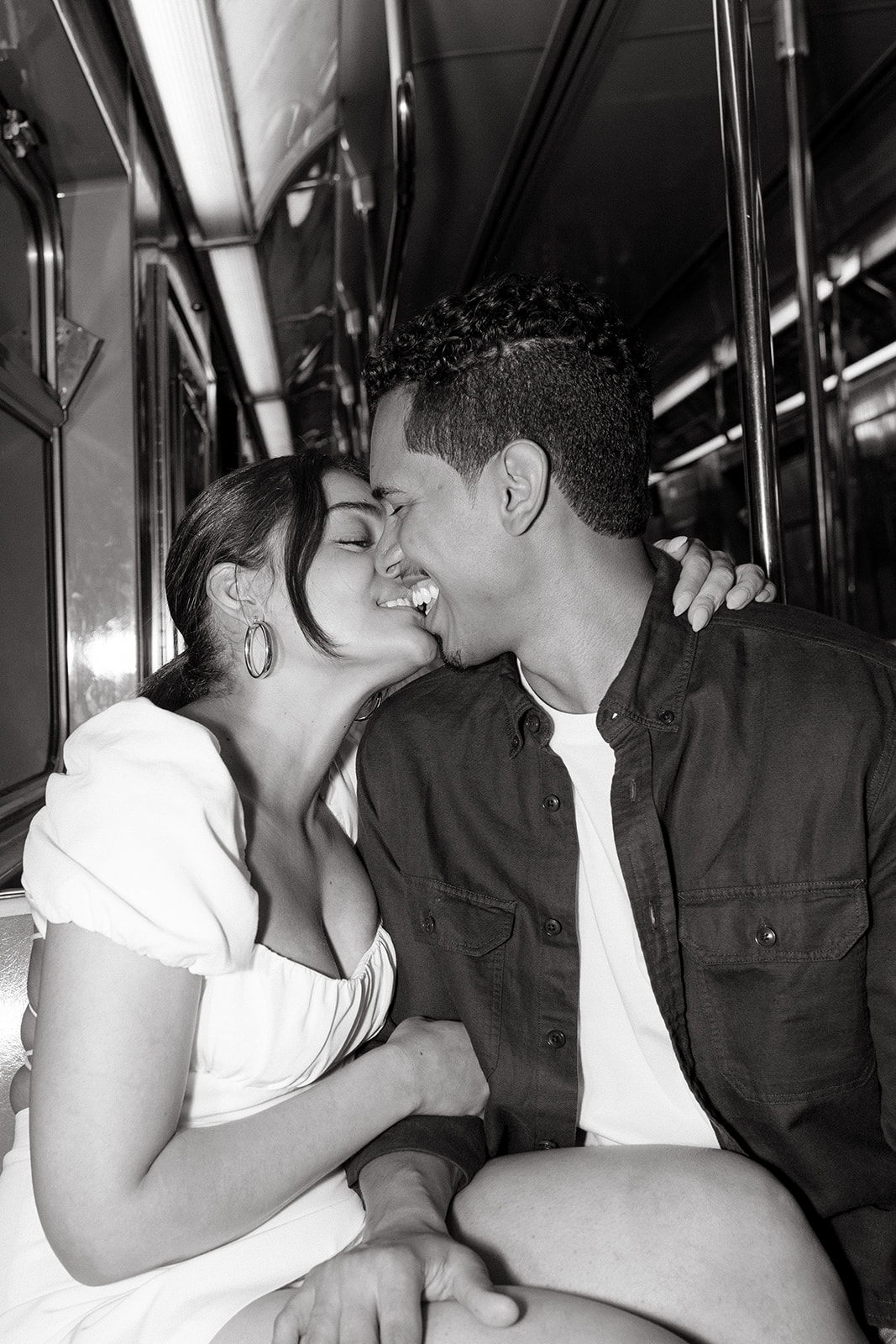 couple kissing in subway car and smiling with direct flash