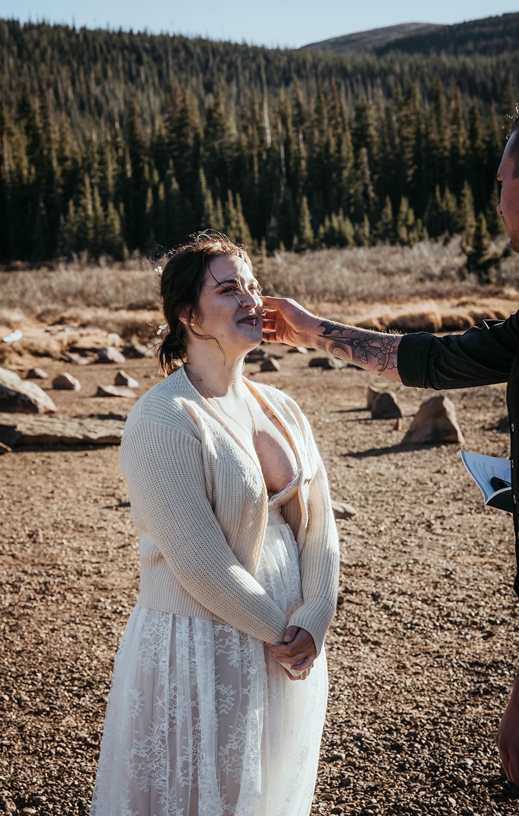 Groom touches bride's cheek during their elopement in the Rocky Mountains 