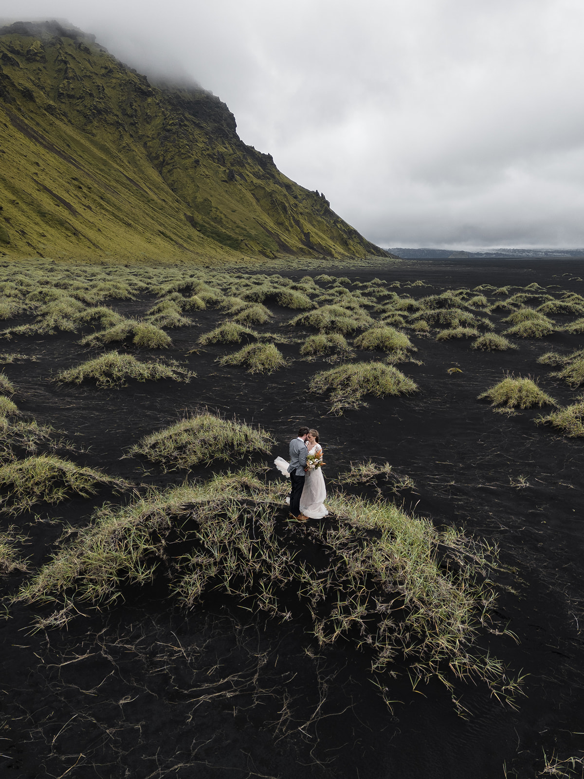 Bride and Groom standing on black sand mounds during their iceland elopement 