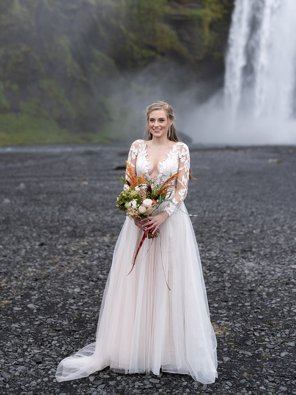 bride taking her elopement pictures at skogafoss iceland 