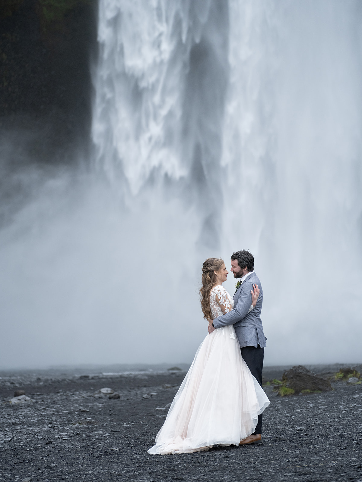 bride and groom in front of skogafoss iceland on their wedding day