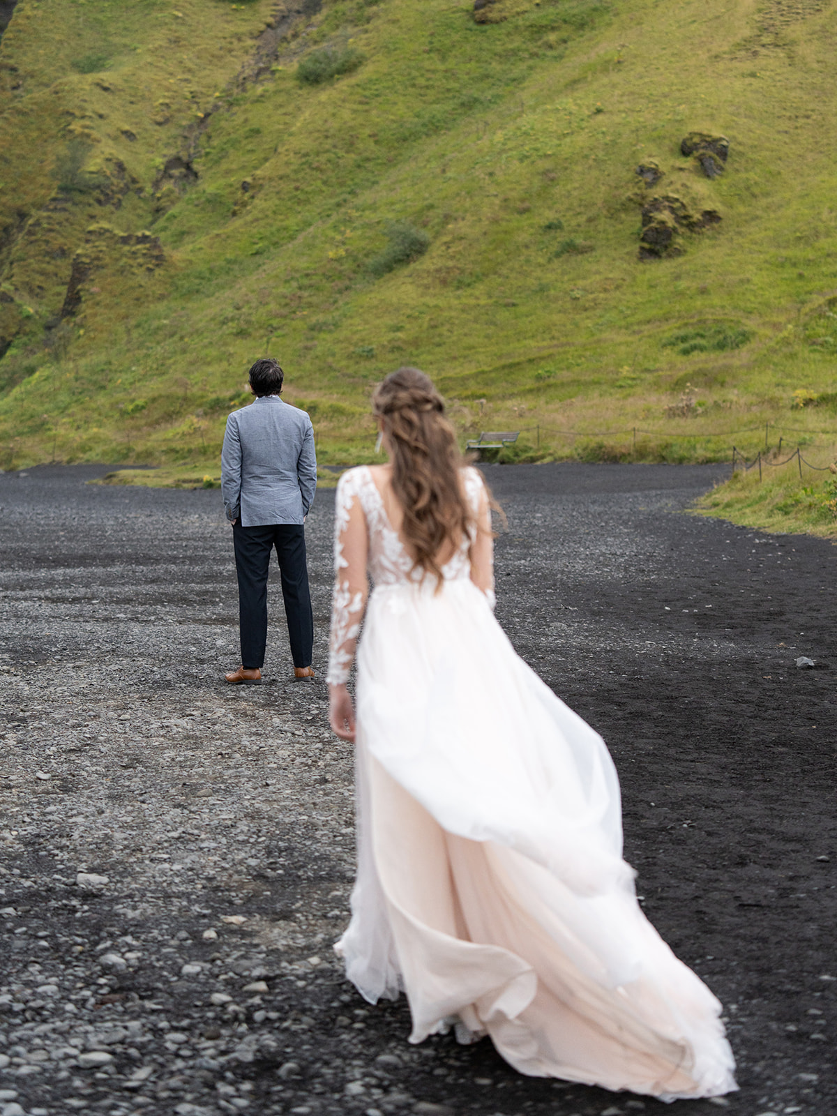 bride and groom having a first look at skogafoss in iceland during their elopement.