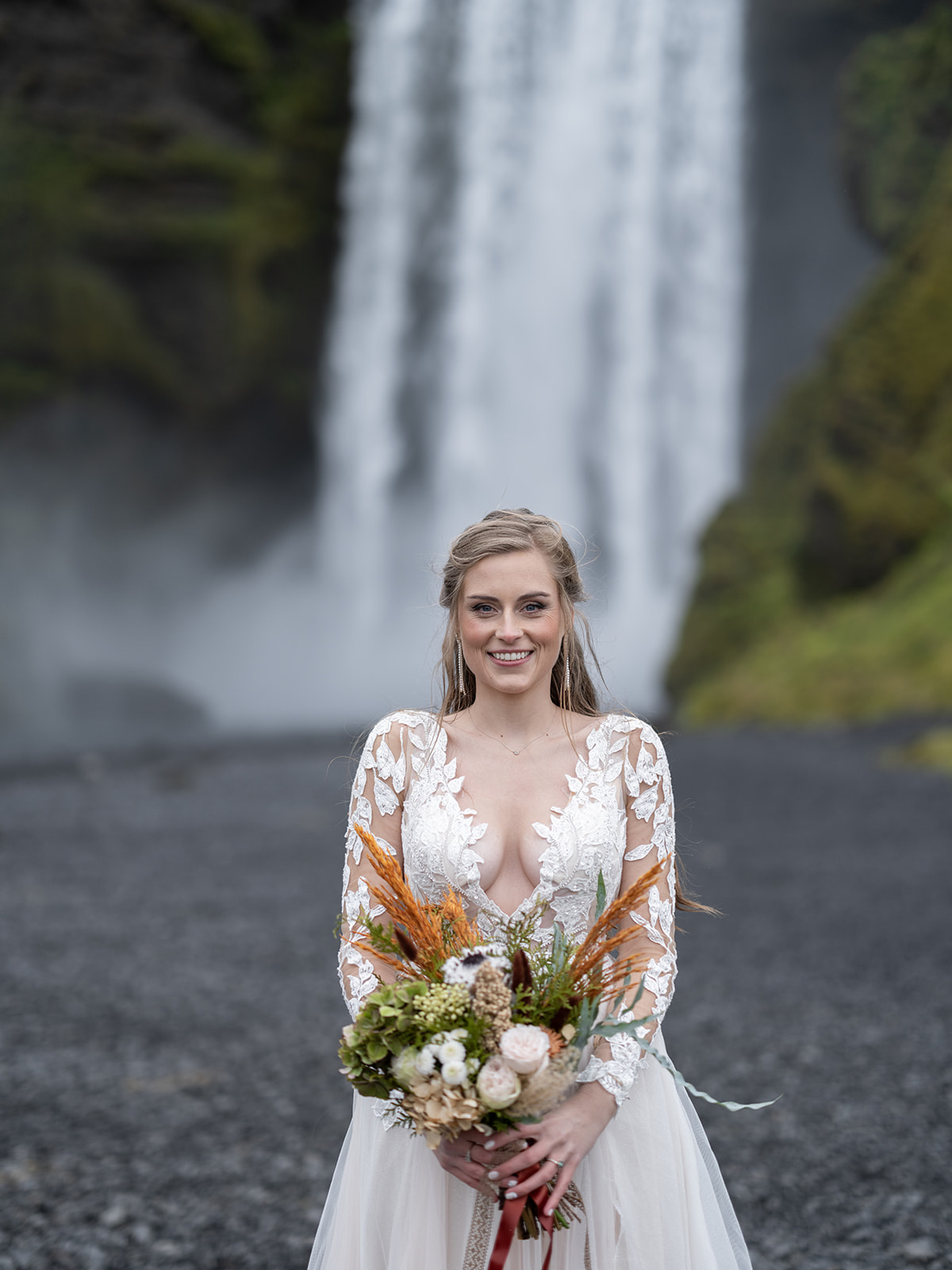 Bride standing in front of Skogafoss on her elopement day