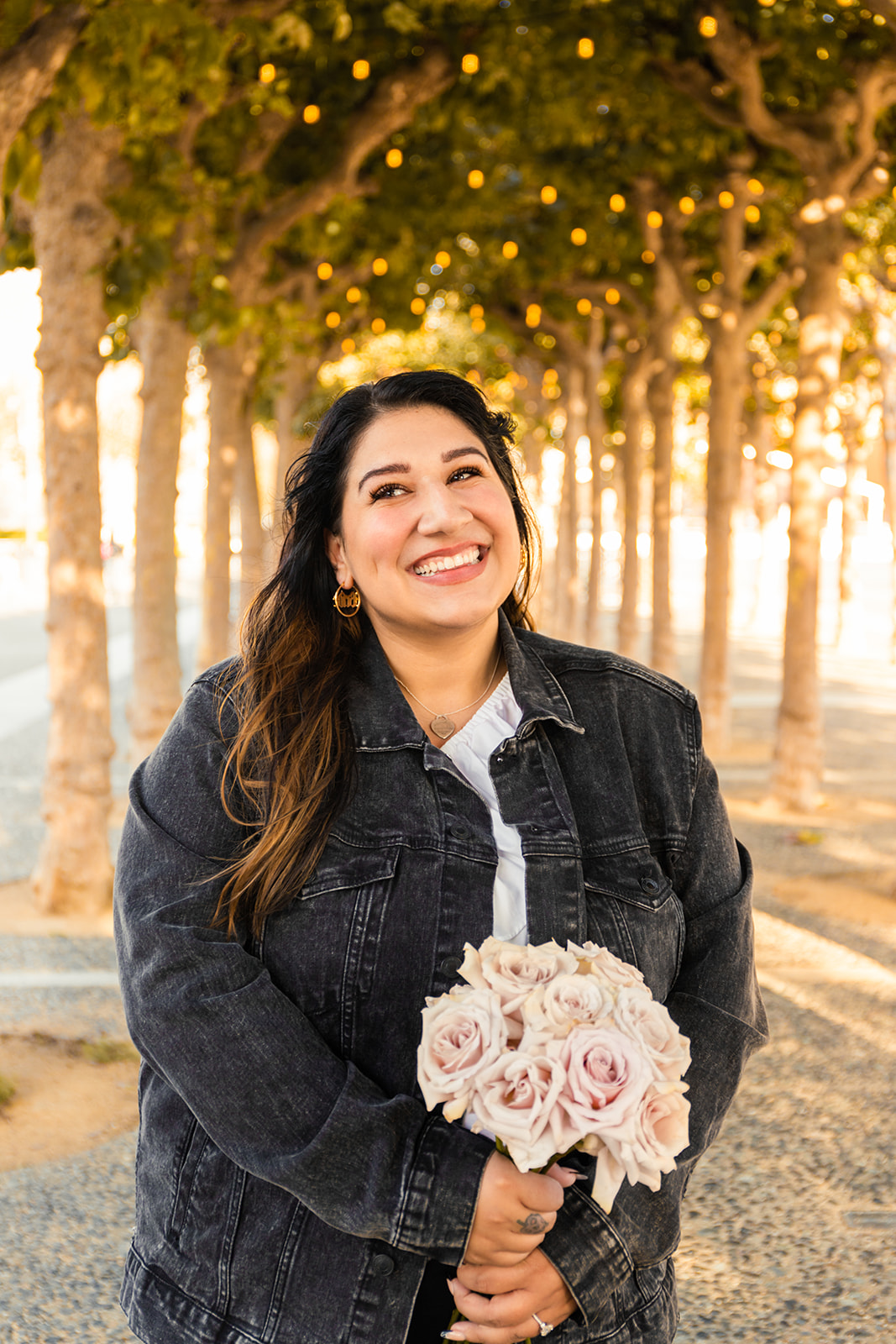 bride smiling in front of trees and market lights