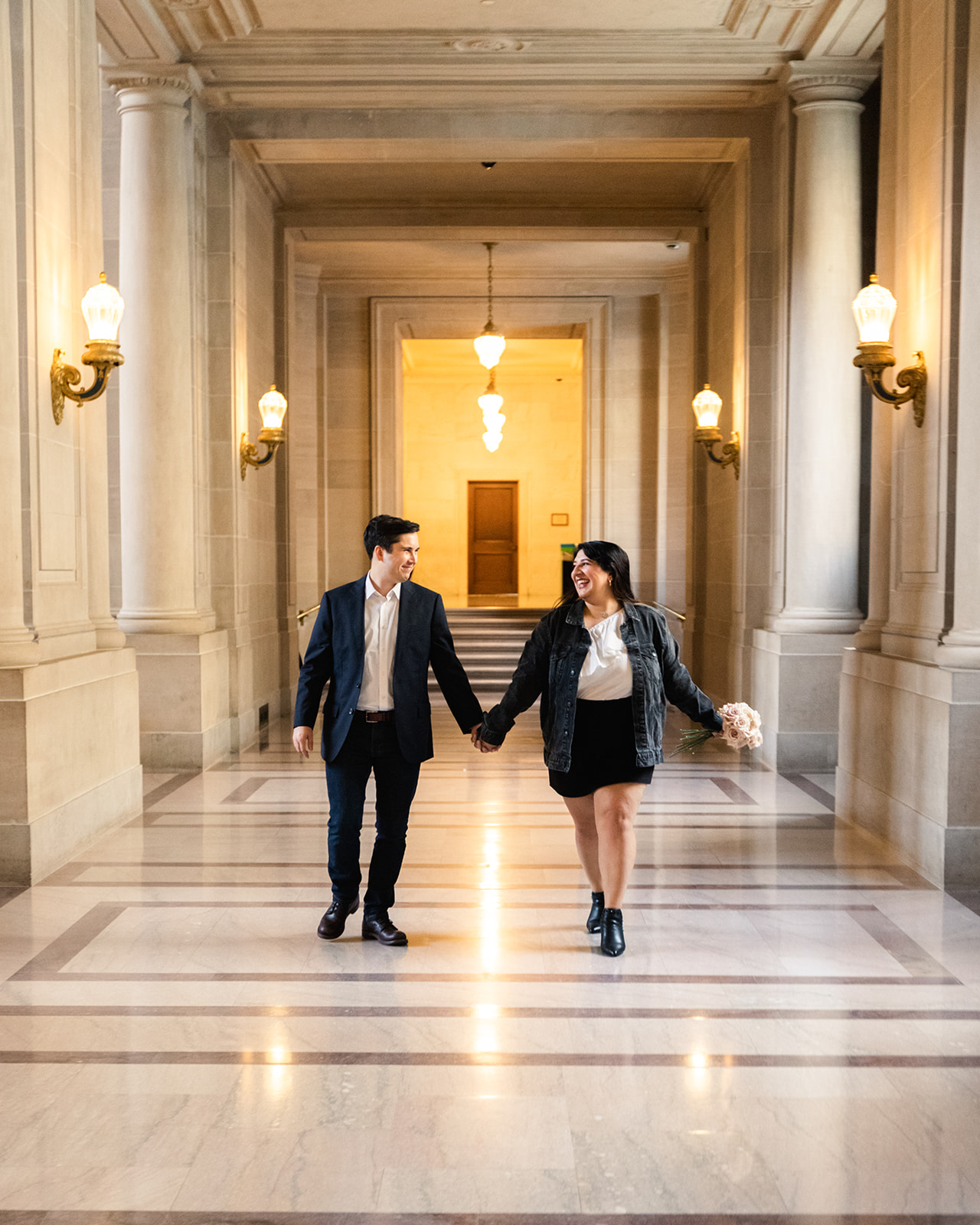 couple walk down halls of san francisco city hall