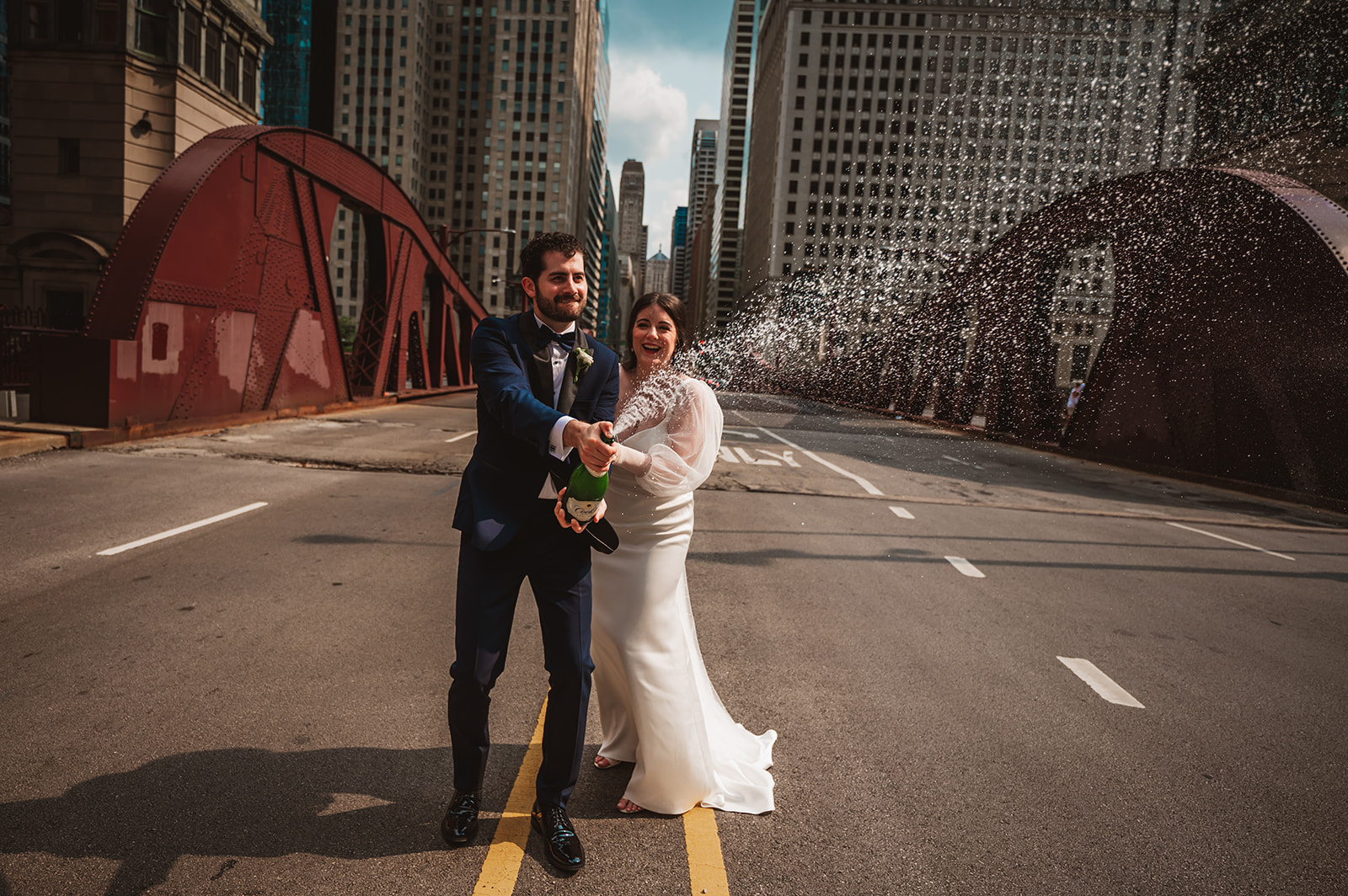 Bride and groom in the middle of the street spraying champagne LaSalle Street Chicago