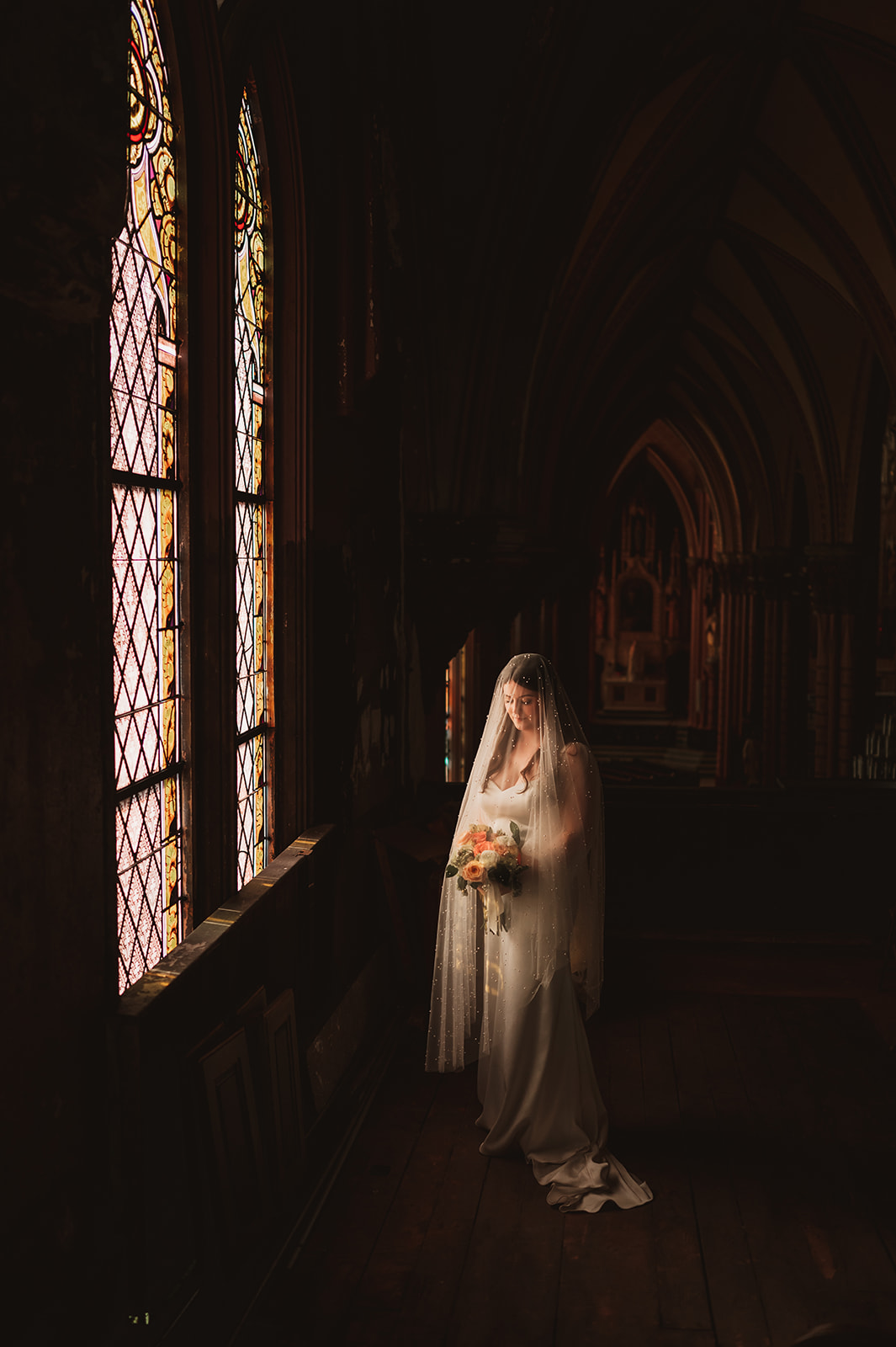 Dreamy, moody bride, under the veil inside of the holy family Church in Chicago photo