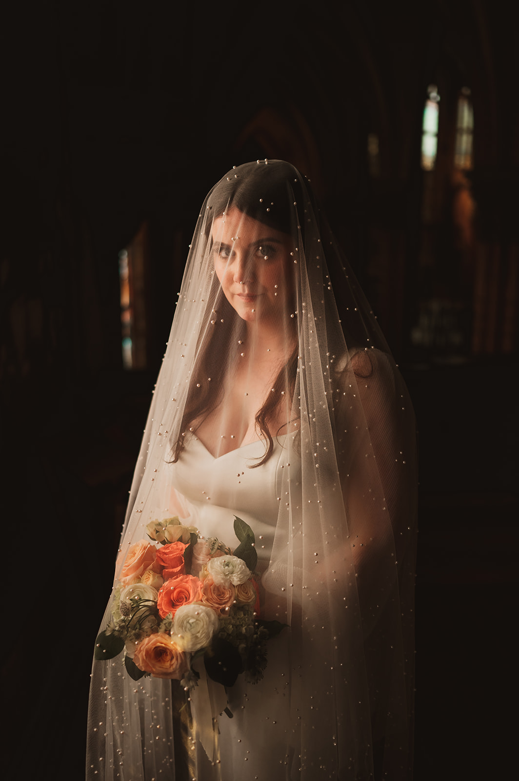 Dreamy, moody bride, under the veil inside of the holy family Church in Chicago photo