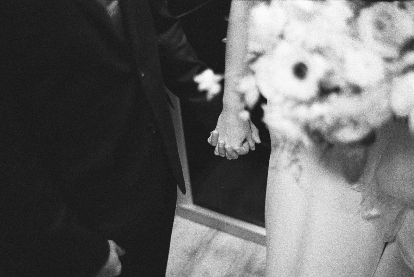 bride and groom hold hands 