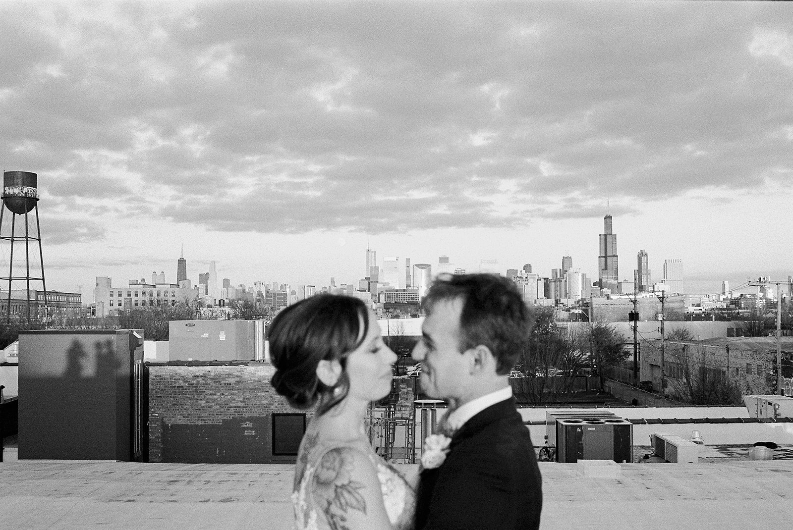 Bride and groom on rooftop of Walden Chicago at sunset with Chicago skyline in the background