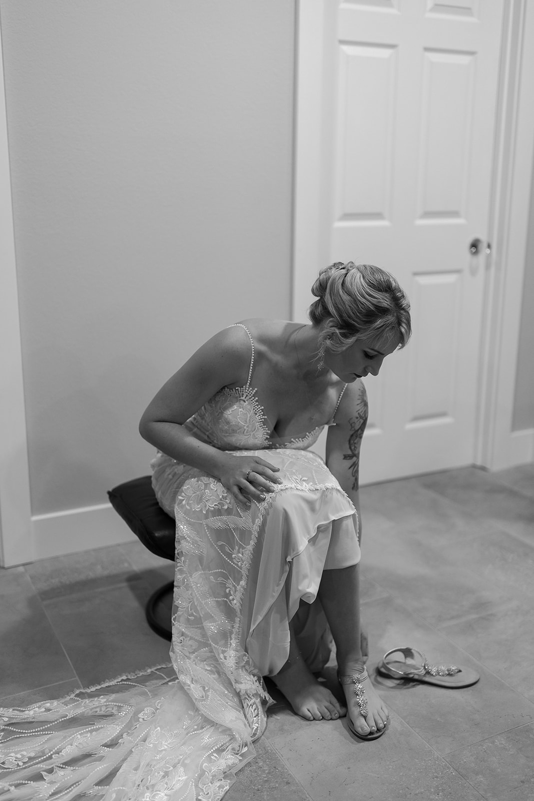 Bride sitting down putting her shoes on