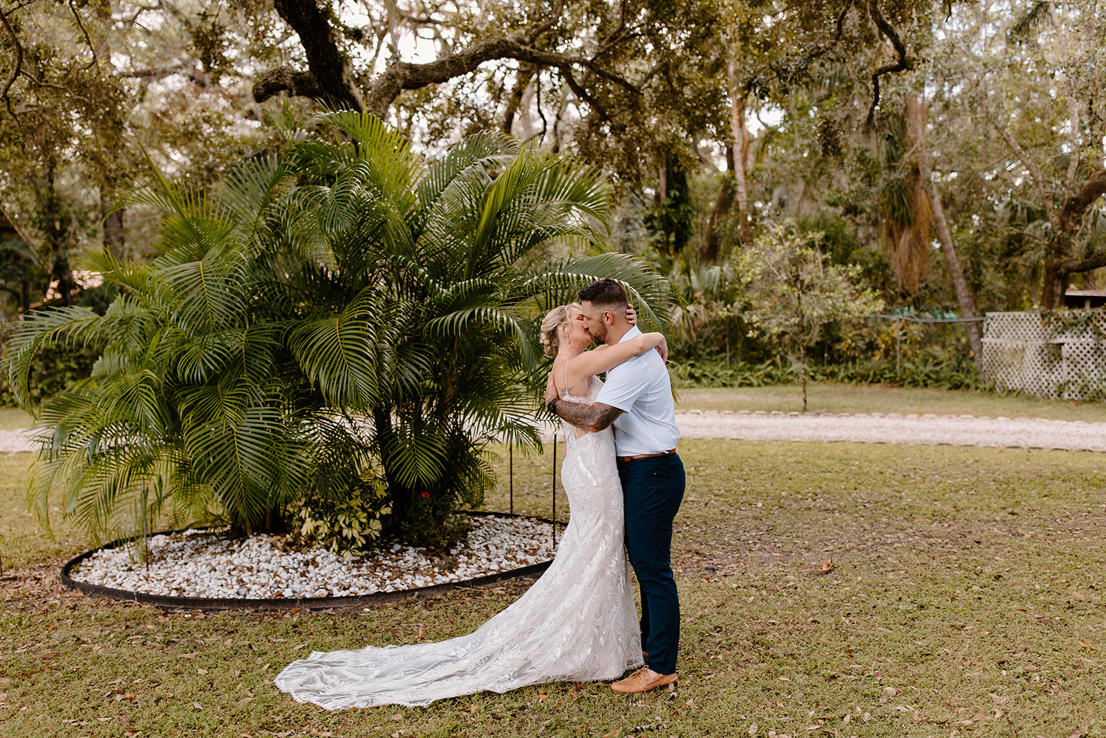 Bride and groom hug in front of a tree