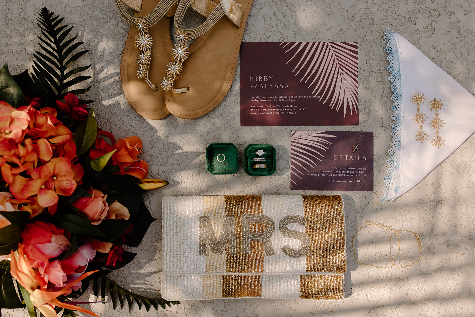 Flat lay of wedding invitations, rings, and other jewelry