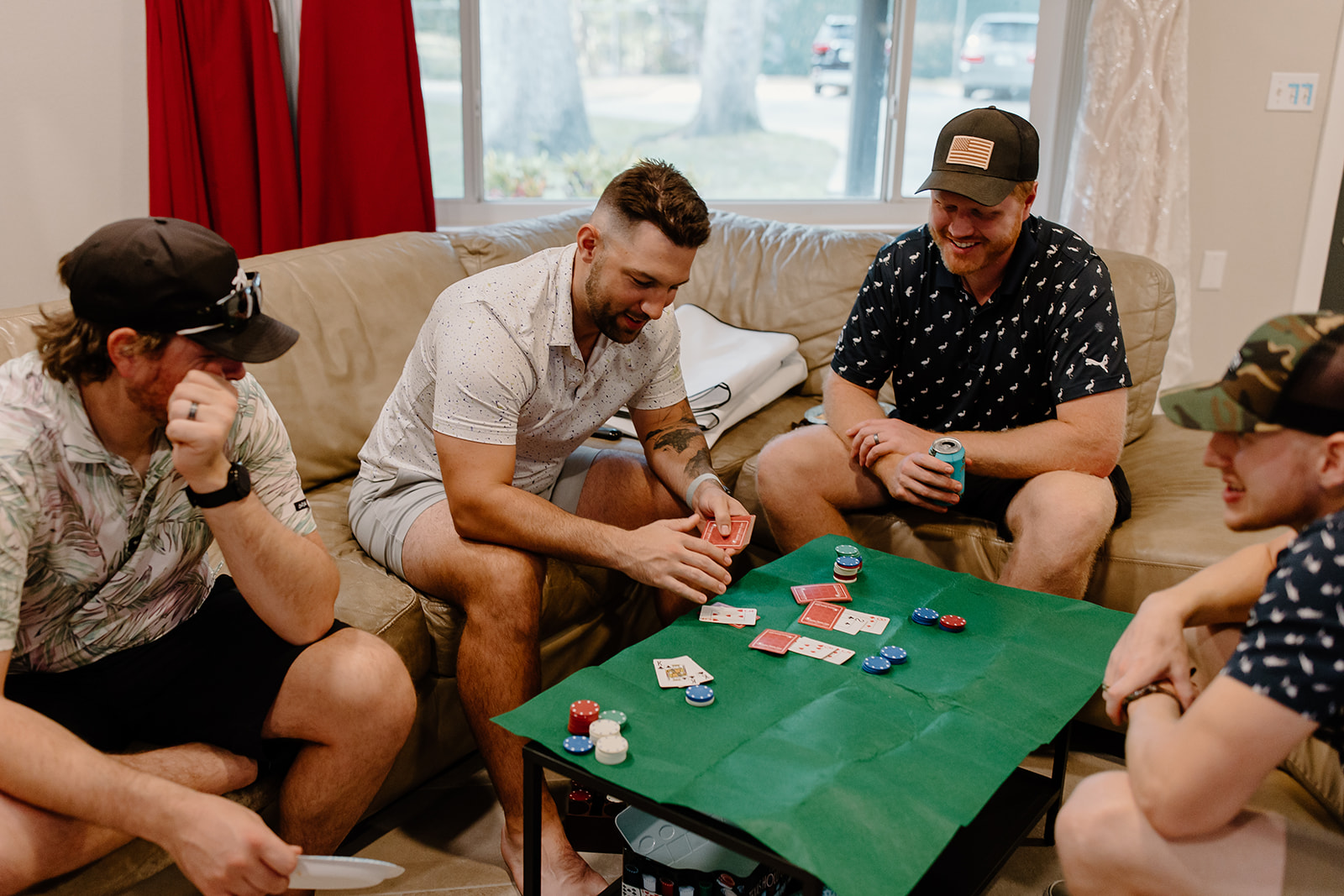 Men playing cards around a couch 