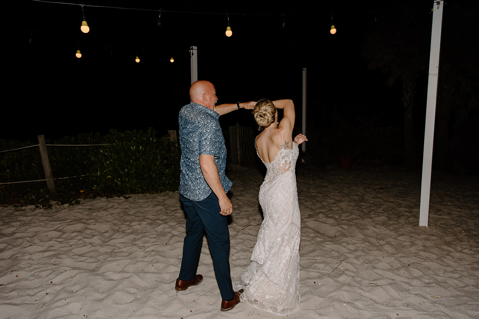 Bride dances with her father on the beach
