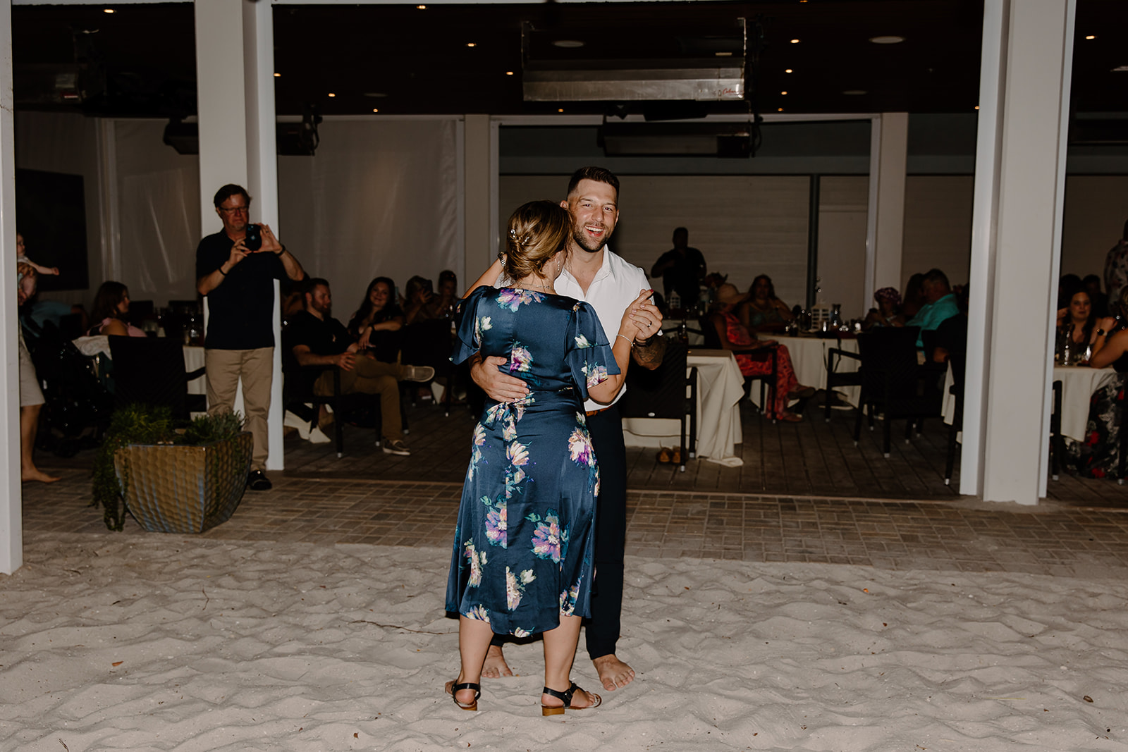 Groom dances with his mother on the beach