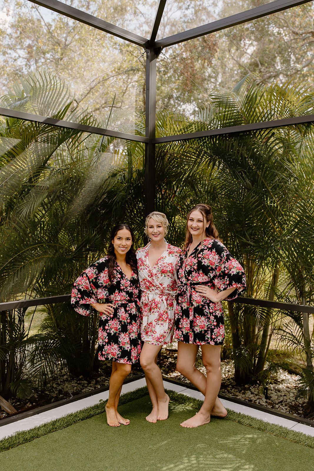 Bride and bridesmaids smiling in their matching floral robes