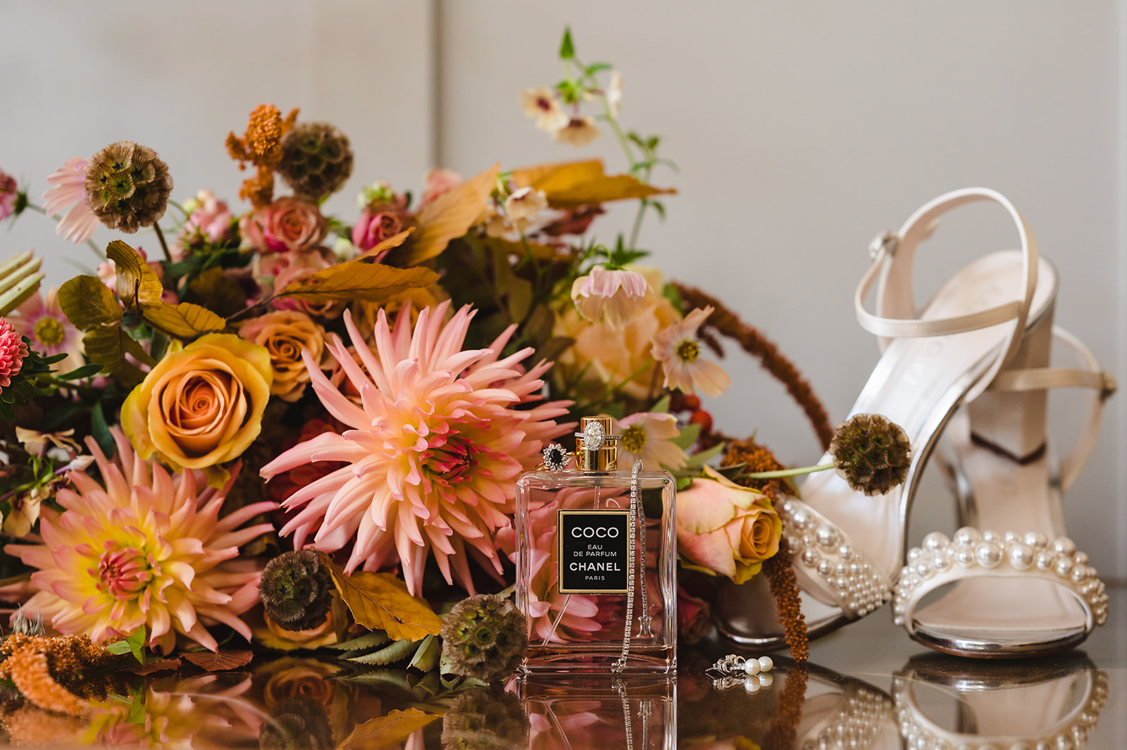 an autumn inspired bouquet with shoes from rainbow club and perfume