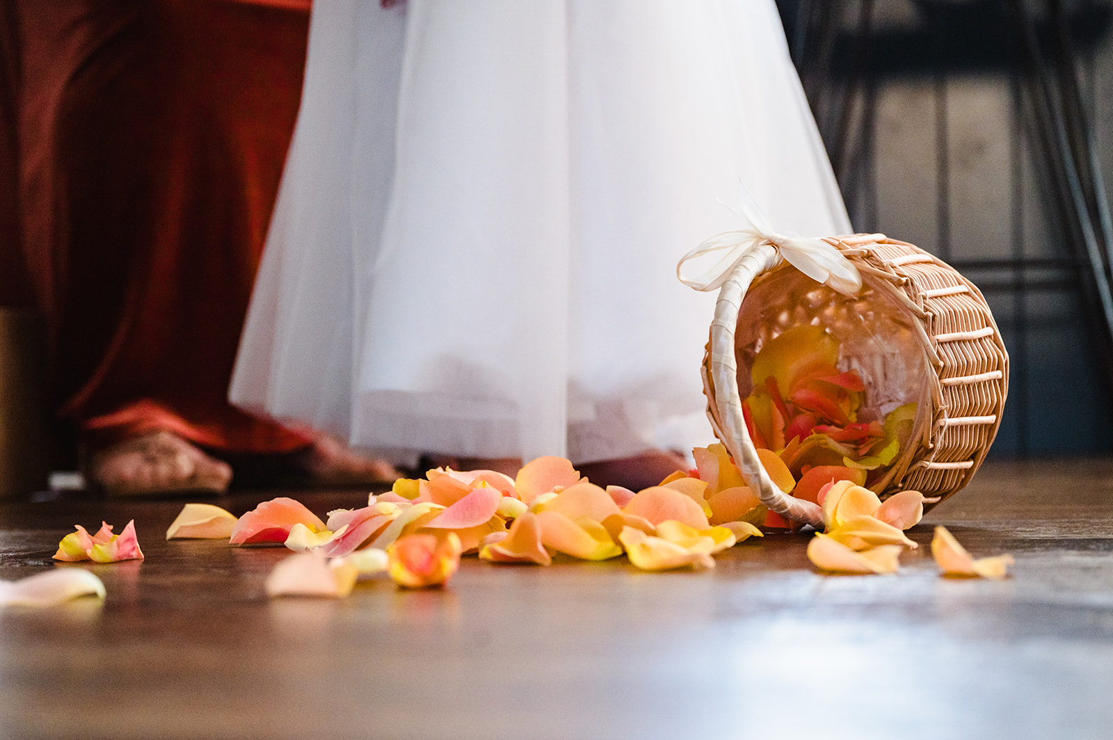 a basket of autumn coloured petals overturned on the floor