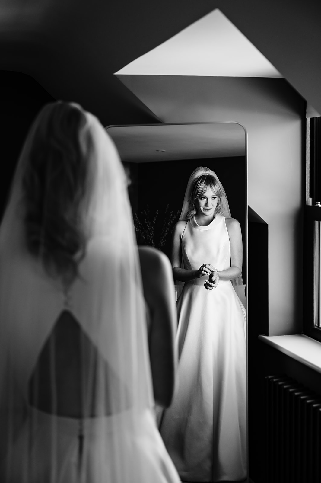 bride seeing herself in the mirror for the first time in her suzanne neville dress