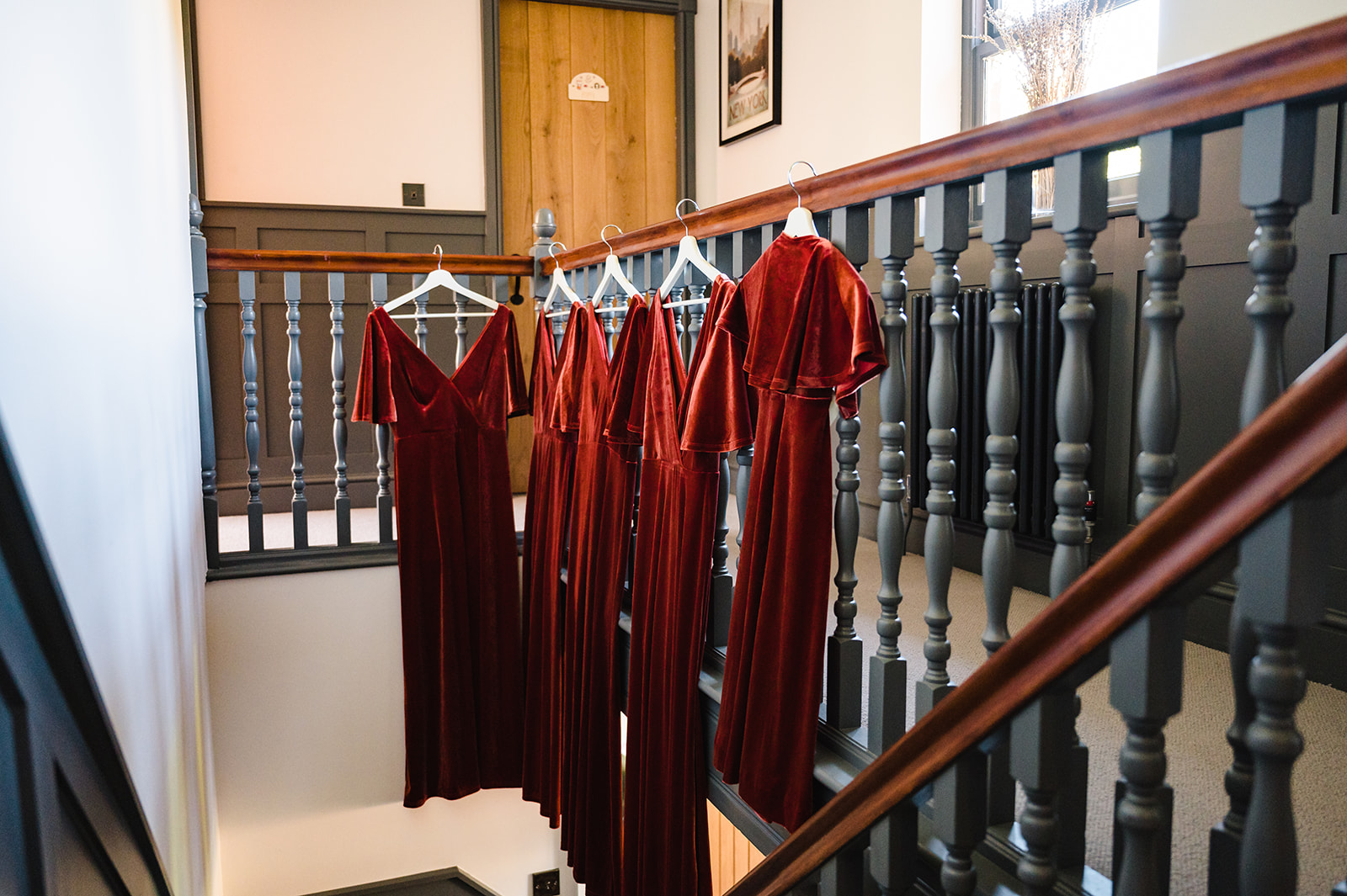 terracotta coloured bridesmaid dresses hung up on stairs
