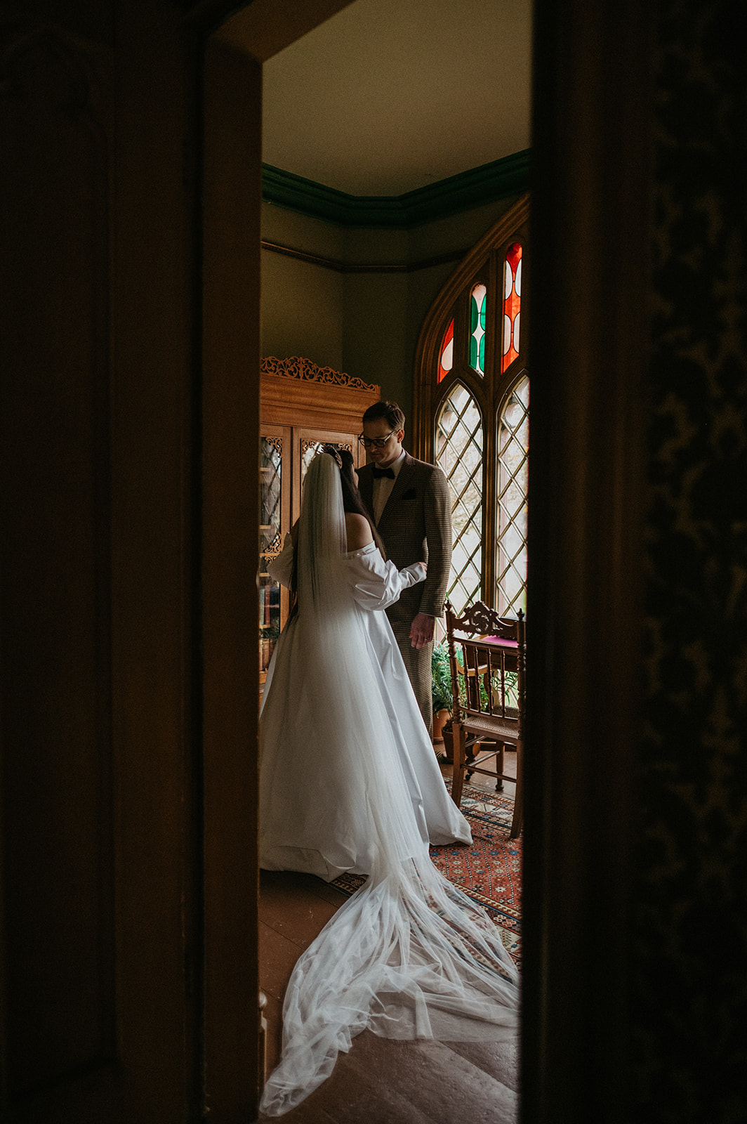 Bride and groom stand together in study at Roseland Cottage