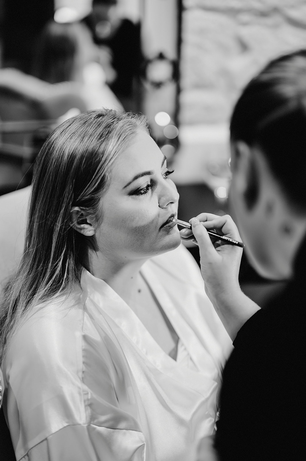 black and white photo of the bride having her make up applied at the pentney abbey wedding venue in norfolk