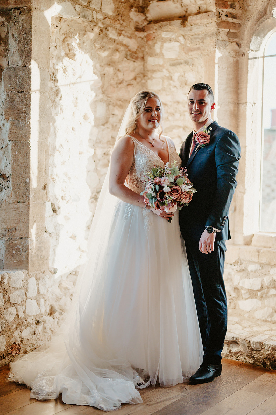 bride and groom pose together inside the tower at the norfolk wedding venue pentney abbey