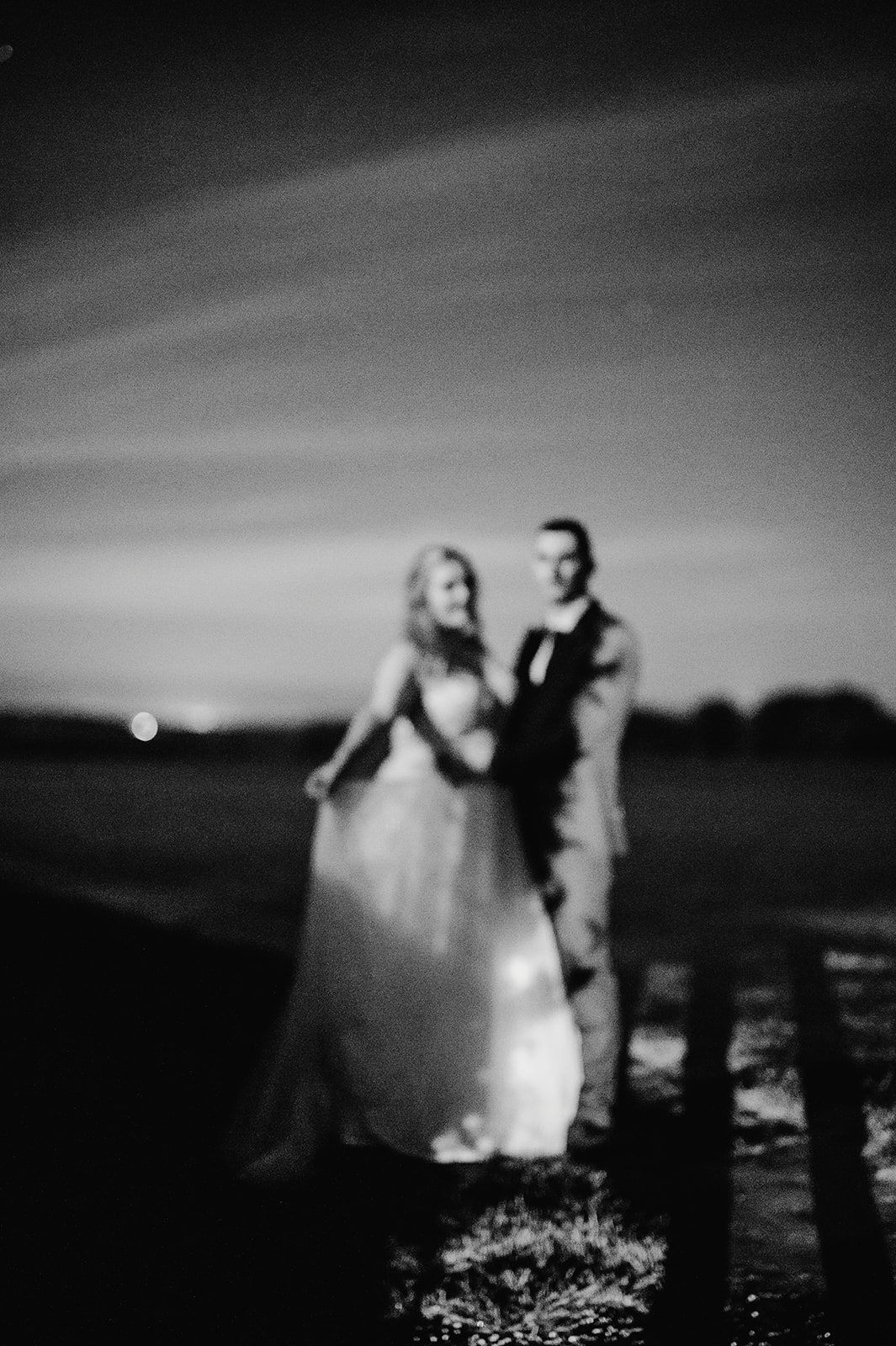black and white film like wedding photo of the bride and groom under the stars at pentney abbey