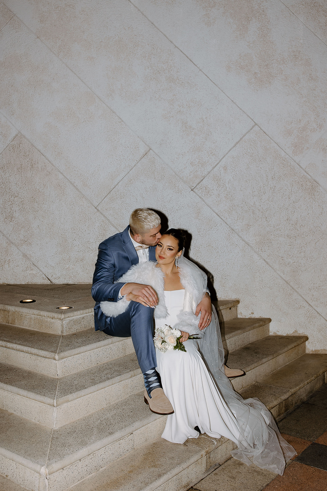 Bride and groom sit on a staircase