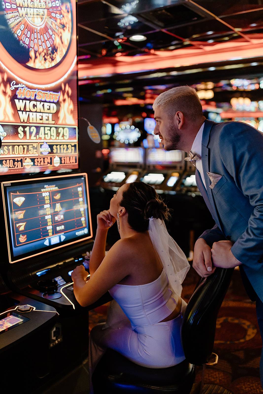 Bride and groom play slots in a casino 