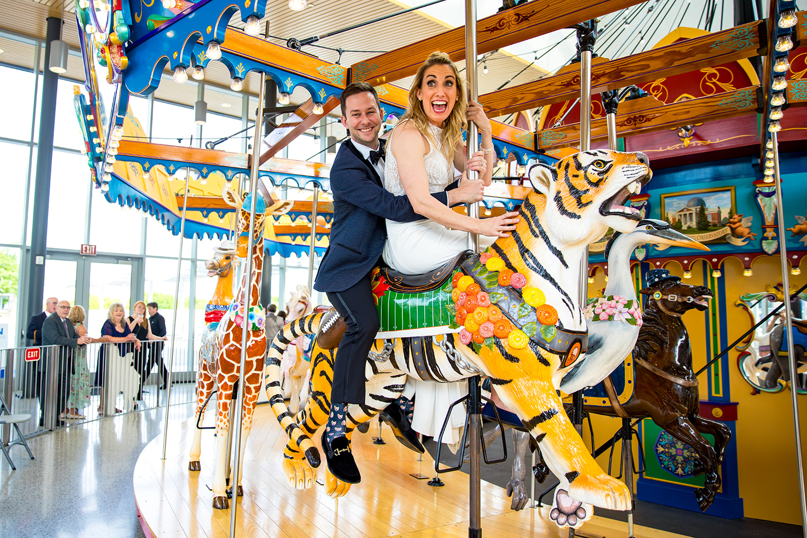 Wedding couple bride and groom enjoy a ride on Carol Ann's Carousel during their reception