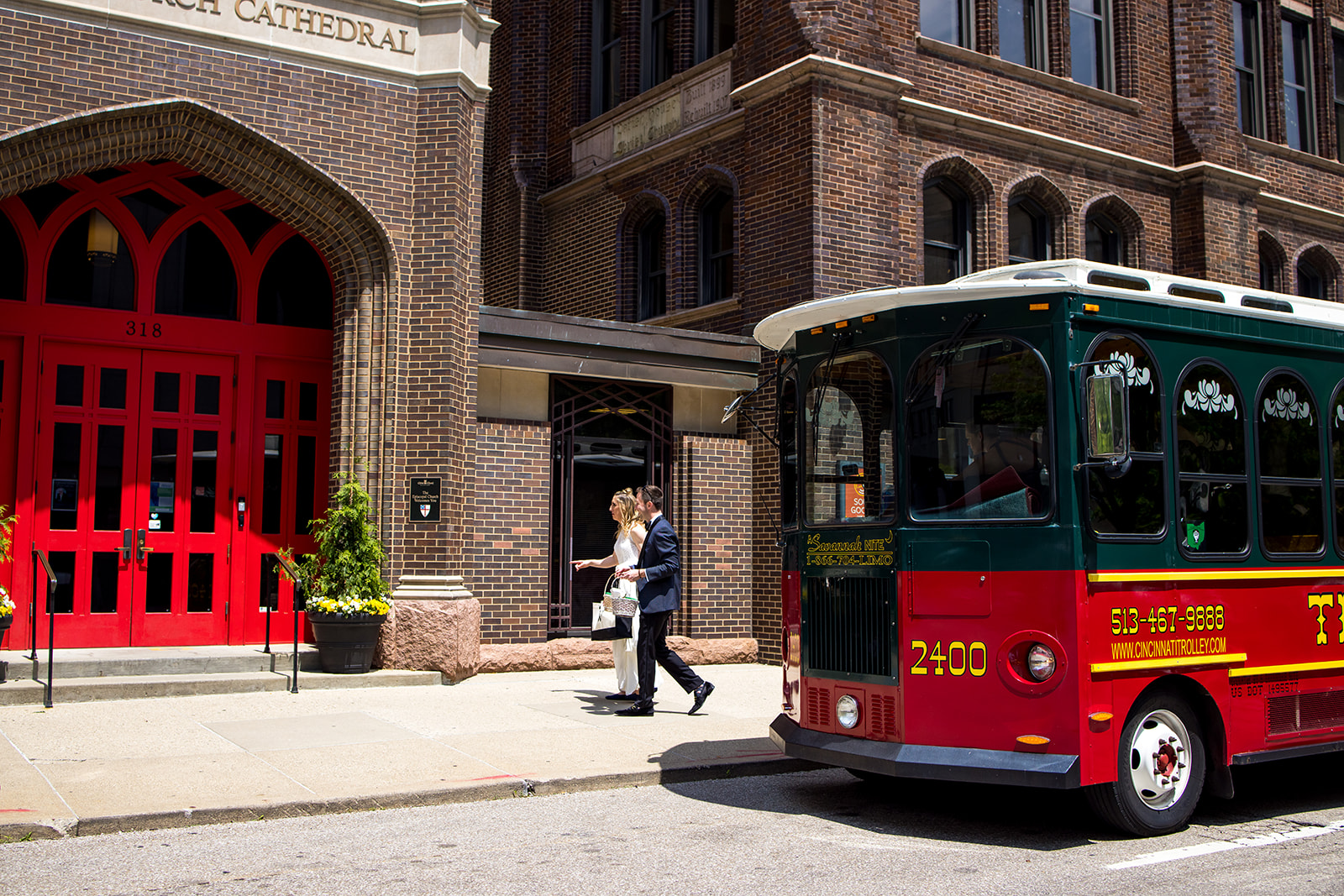 Trolley parked outside church in Cincinnati, OH while bride and groom walk into ceremony