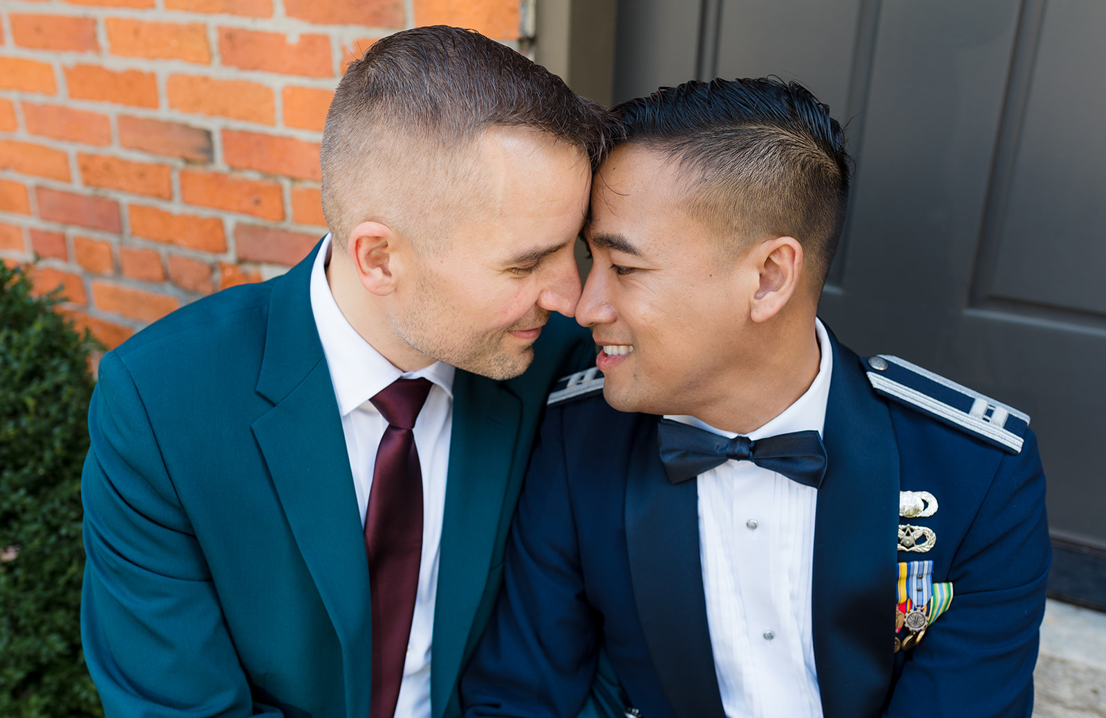 A close up of two grooms nuzzling each other during their couples portraits.