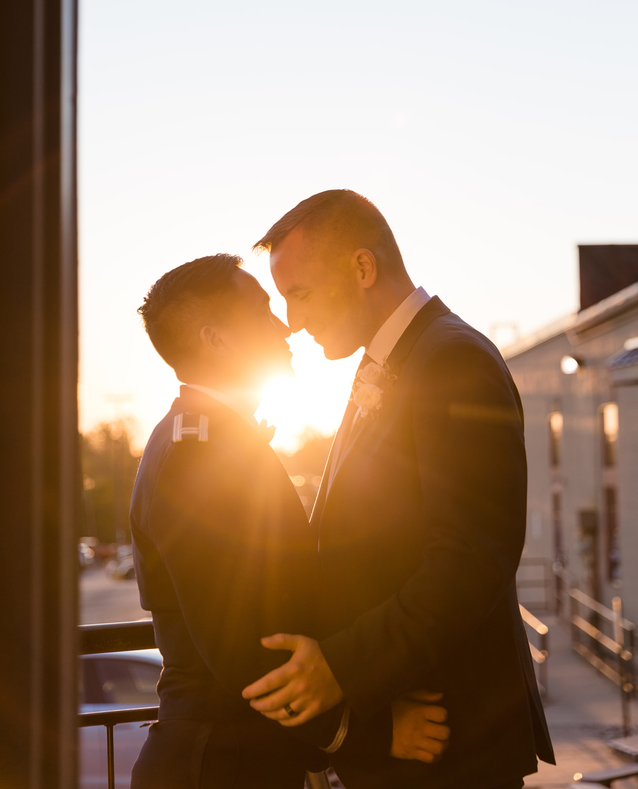 A golden sunset portrait of two grooms embracing