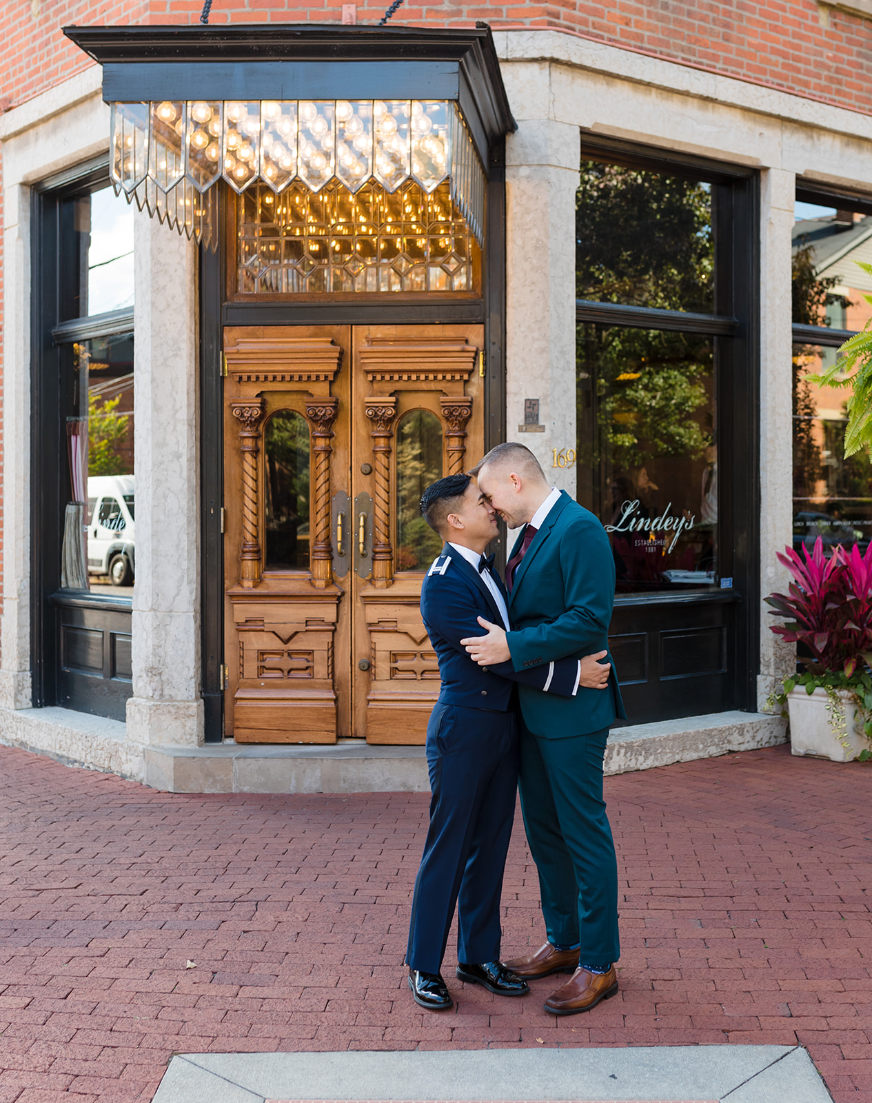 The glittery front door of Lindeys in German Village serves as a classy backdrop as these two grooms embrace 