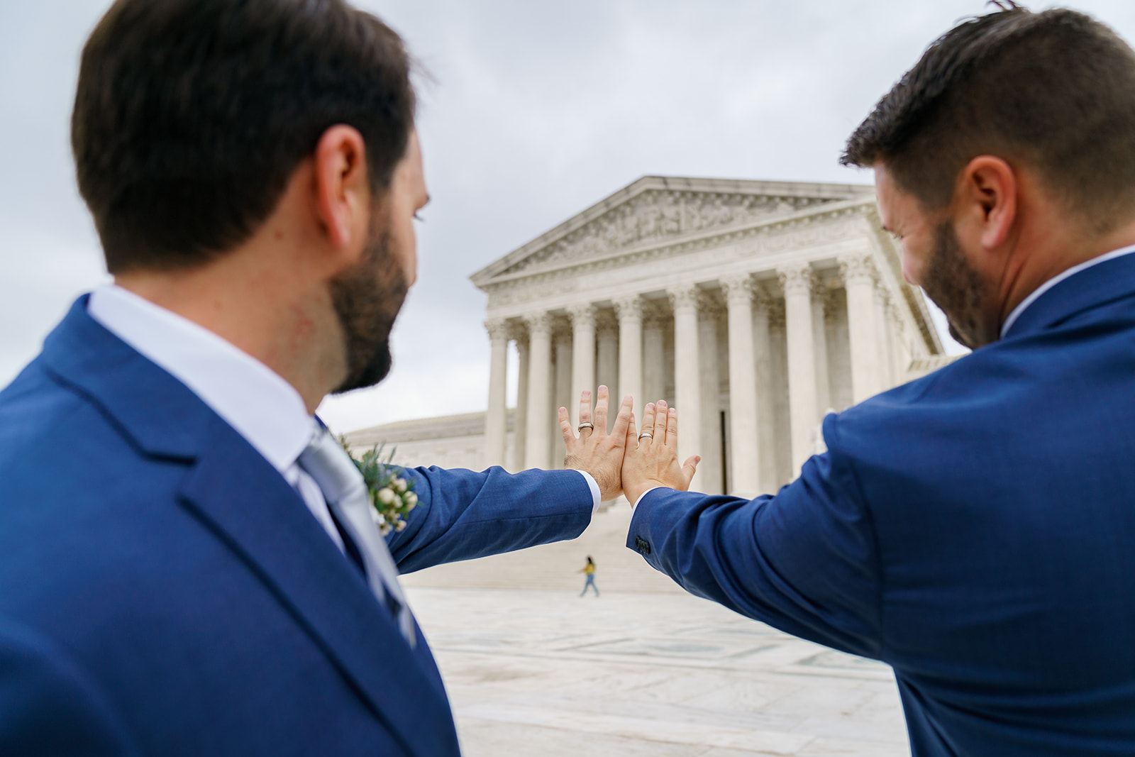 Same-sex couple show wedding rings in front of Supreme Court