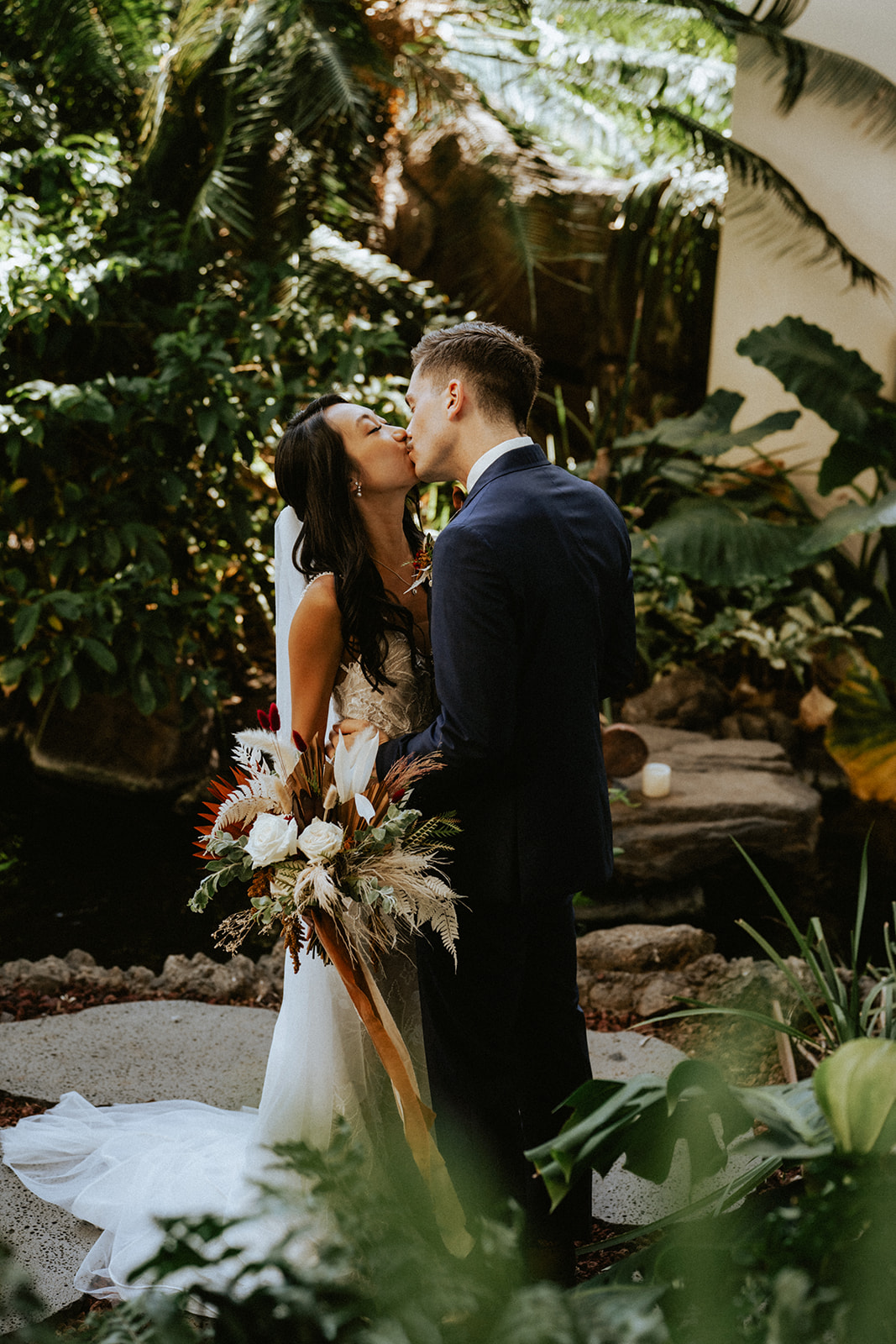 Bride and groom kissing in the garden of Four Seasons Resort