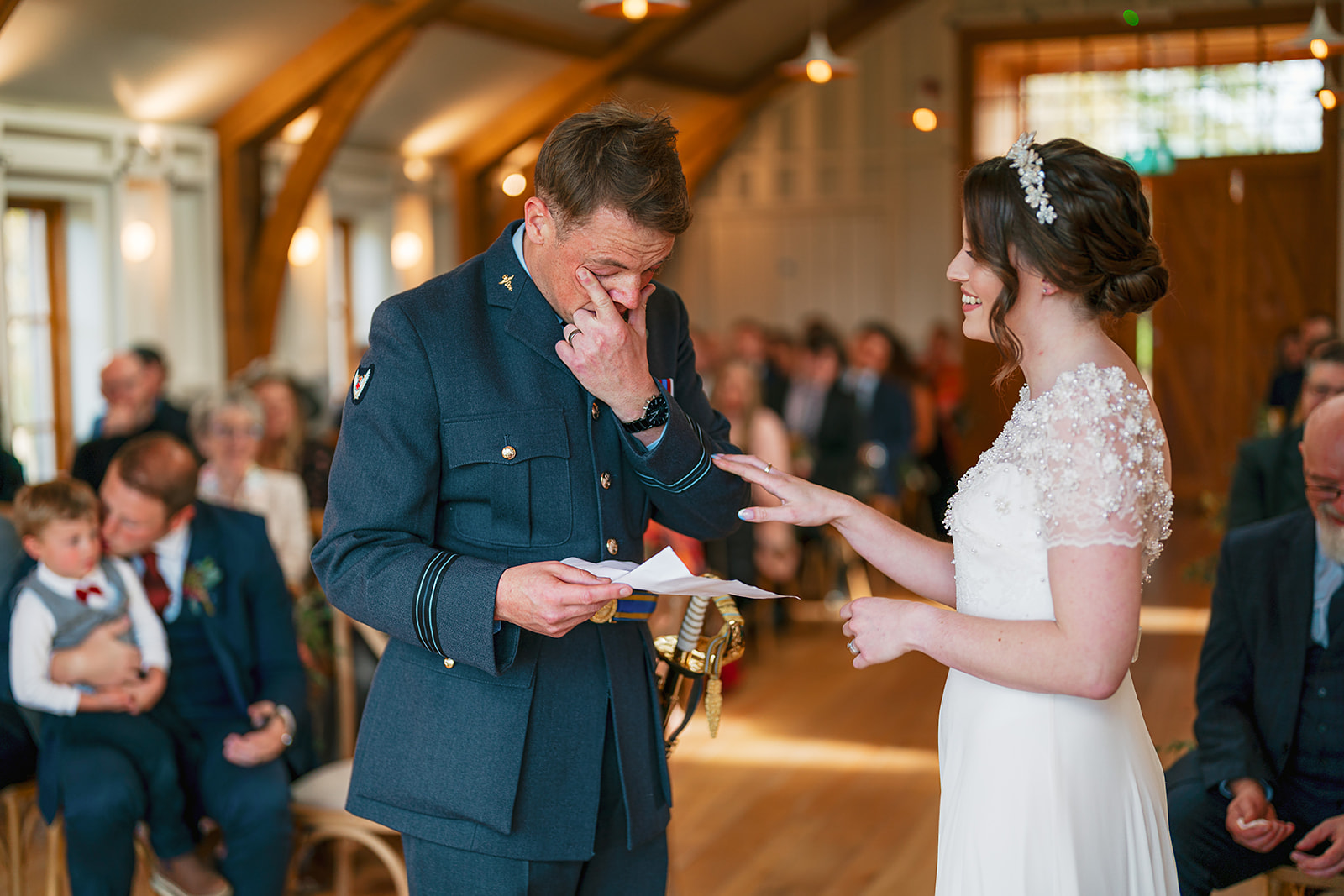 groom wipes away a tear during an emotional ceremony  at the Barn, Hyde House, Cotswolds.