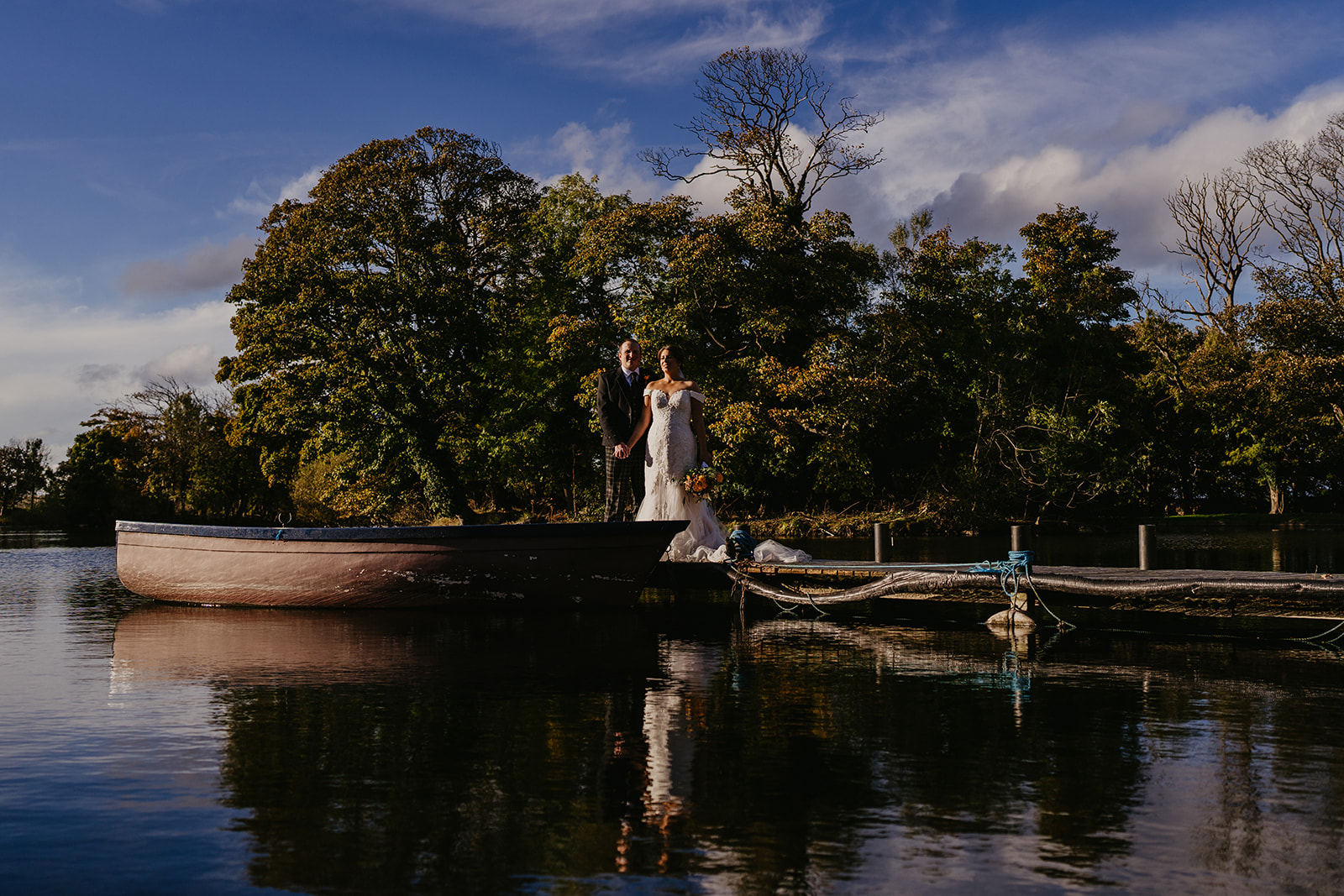 Bride and Groom look over the gorgeous Scottish Loch on their wedding day at Broxmouth Courtyard