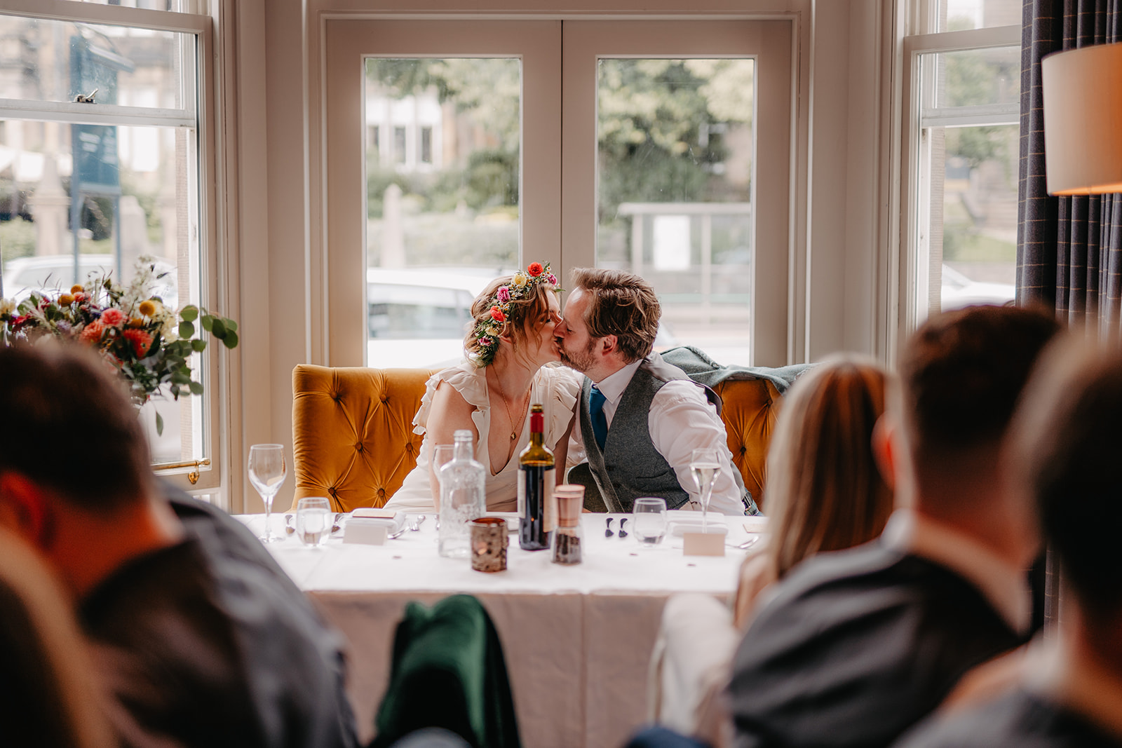 bride and groom kiss at the dinning table
