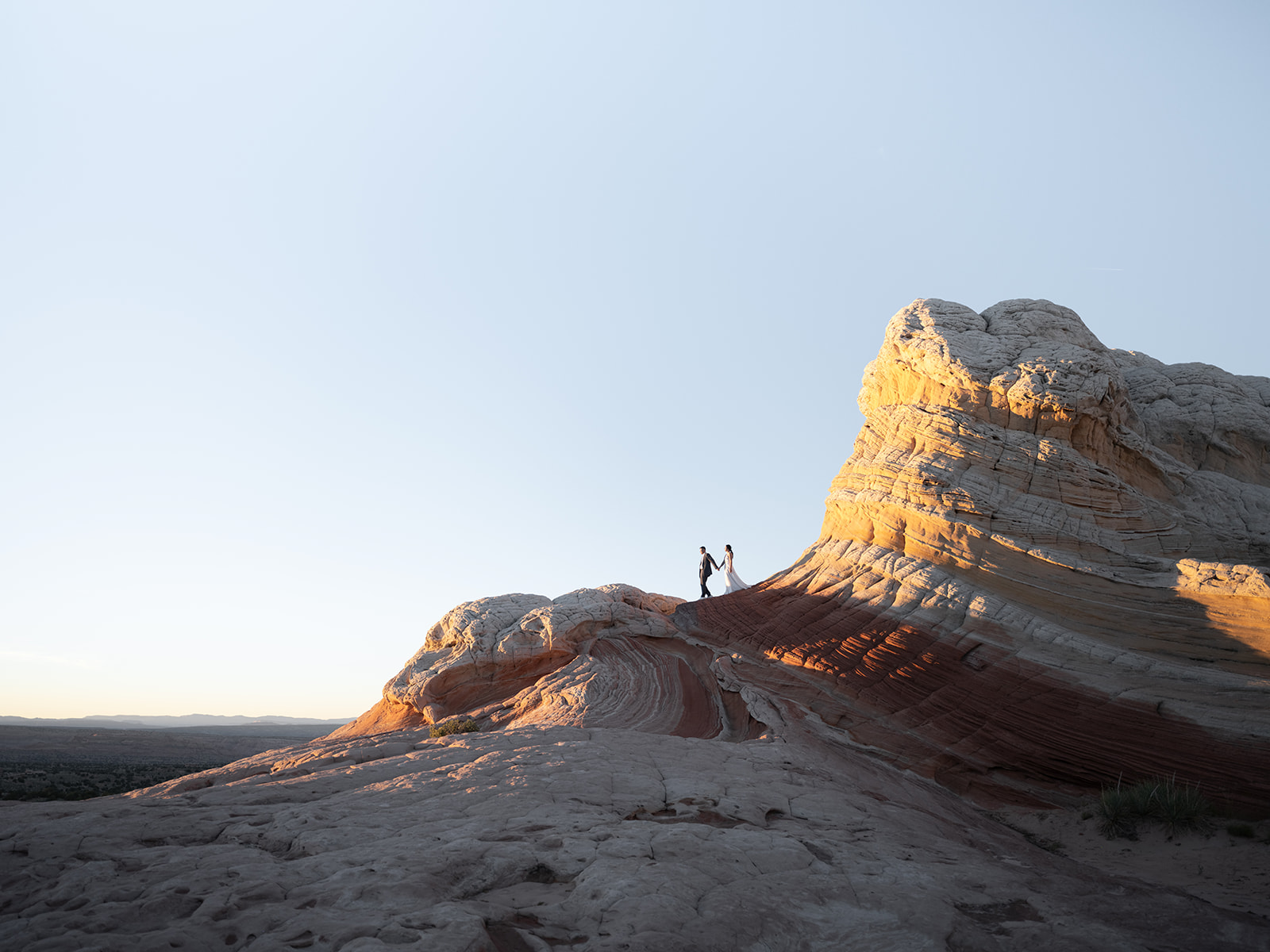 Couple taking pictures during their elopement on the cliffs in White Pocket Arizona 