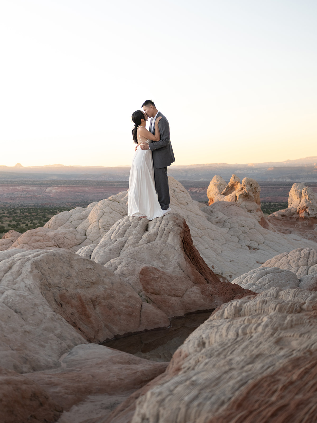 Couple kissing on top of a sandstone formation in White Pocket Arizona 
